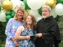 Pastor of St. Augustine's, Fr. Peter Gori O.S.A. (right) and admissions director Paula O'Dea (left) hand Abby Aguedelo her diploma on graduation day.